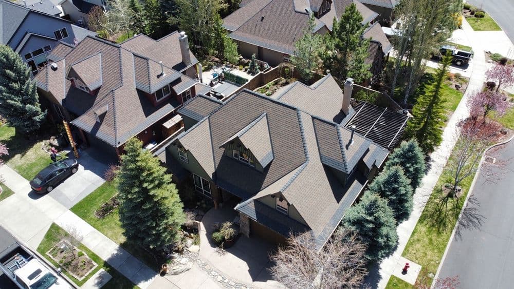 Aerial view of a suburban neighborhood showcasing houses with landscaped yards and trees.