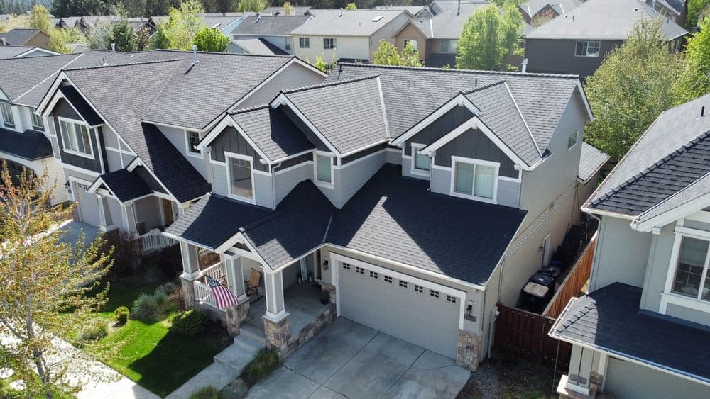 Aerial view of a modern suburban home with a garage and well-maintained landscaping.